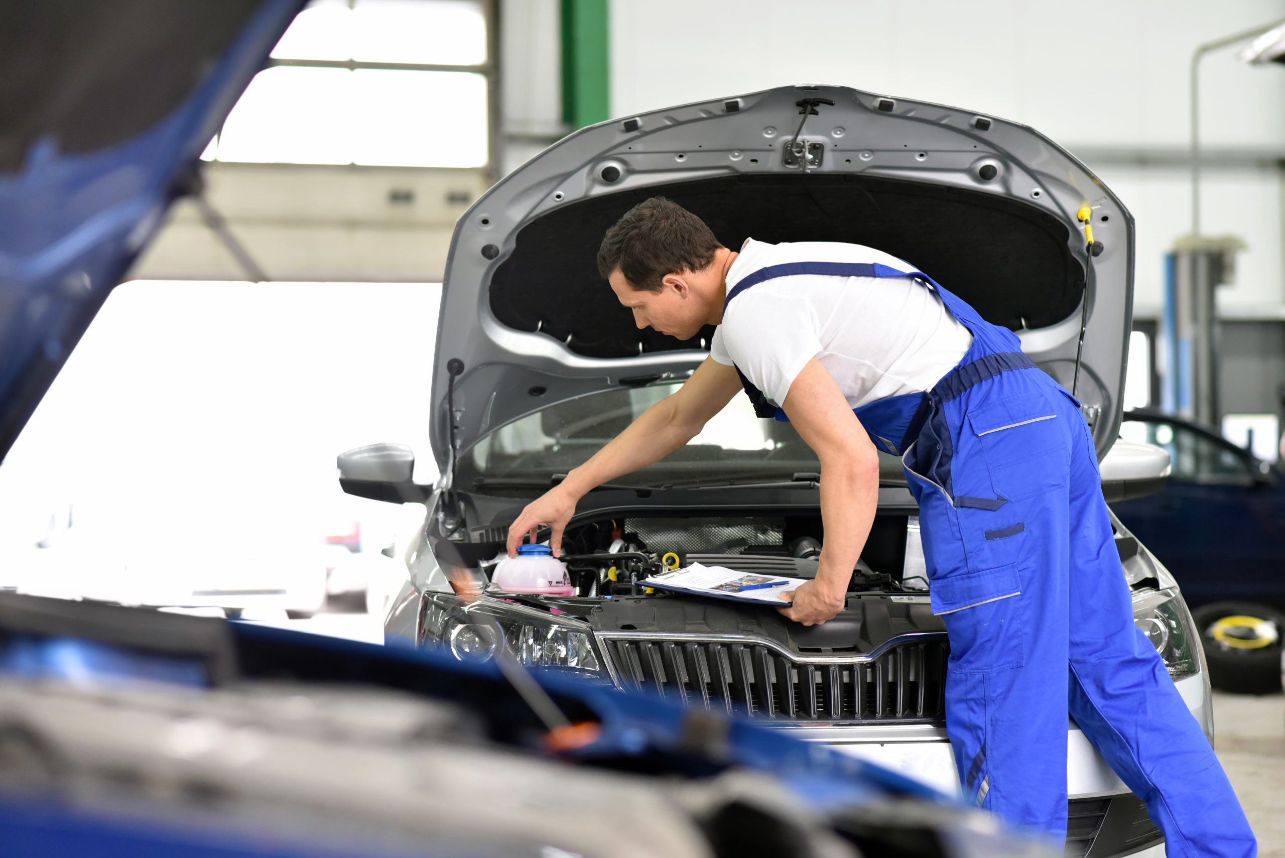 car mechanic in a workshop - engine repair and diagnosis on a vehicle